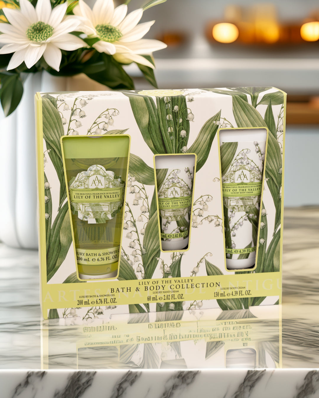 Bath and body set with floral design packaging on a marble surface.
