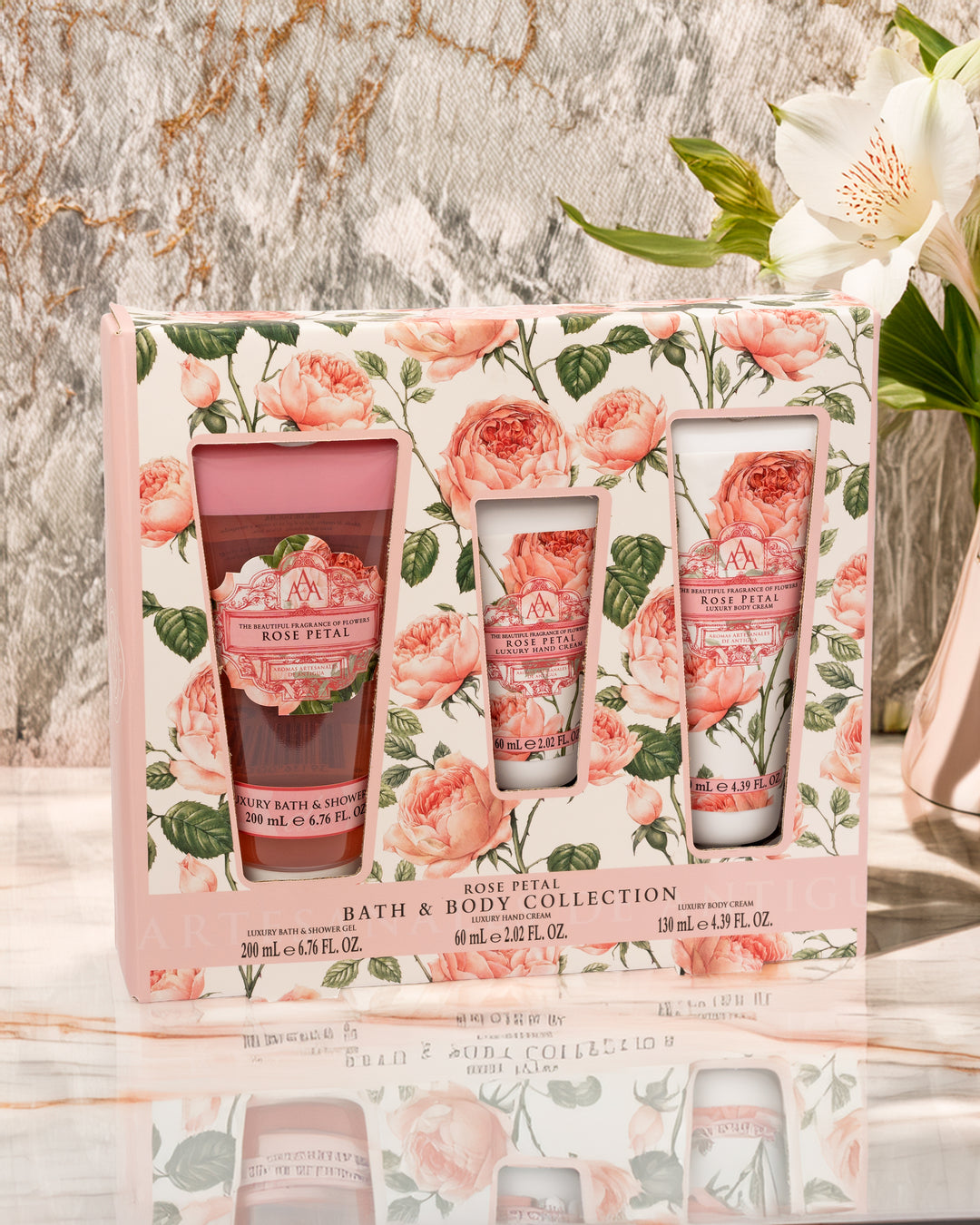 Rose Petal bath and body collection set with floral packaging on a marble surface.