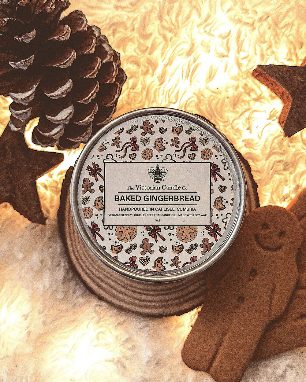 Candle tin labeled 'Baked Gingerbread' with decorative elements on a soft, warm background.