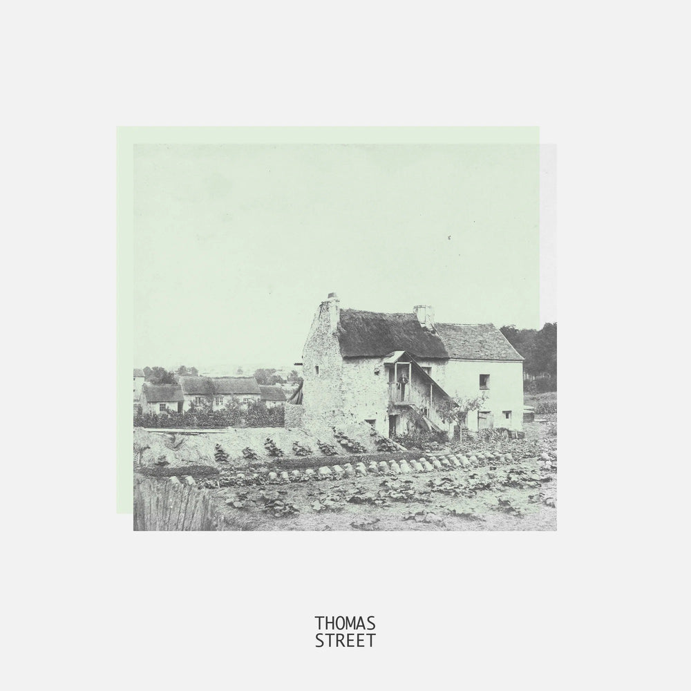 Vintage black and white photograph of a building with 'THOMAS STREET' text at the bottom.