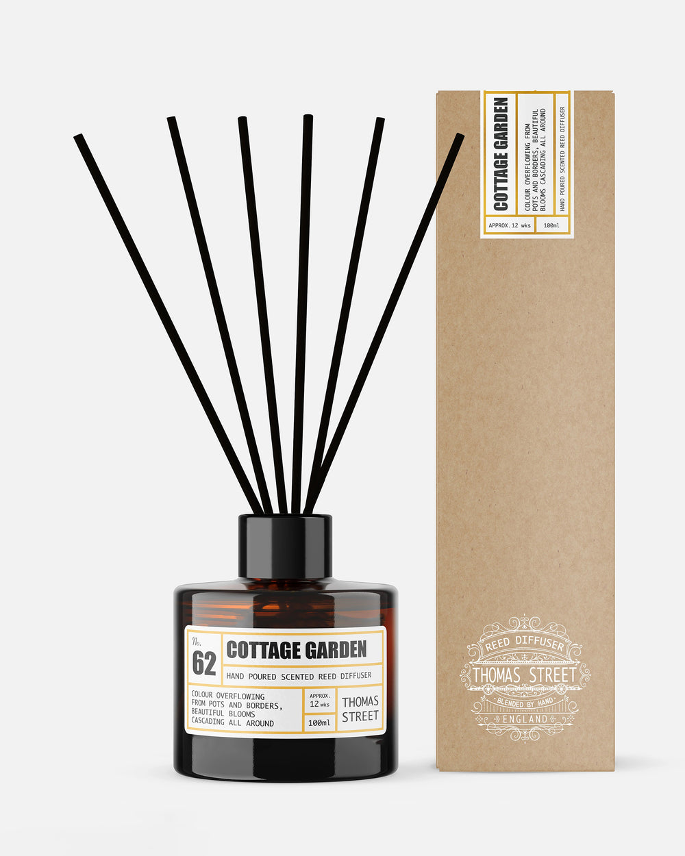 Diffuser bottle labeled 'Cottage Garden' with black sticks and a cardboard box on a white background
