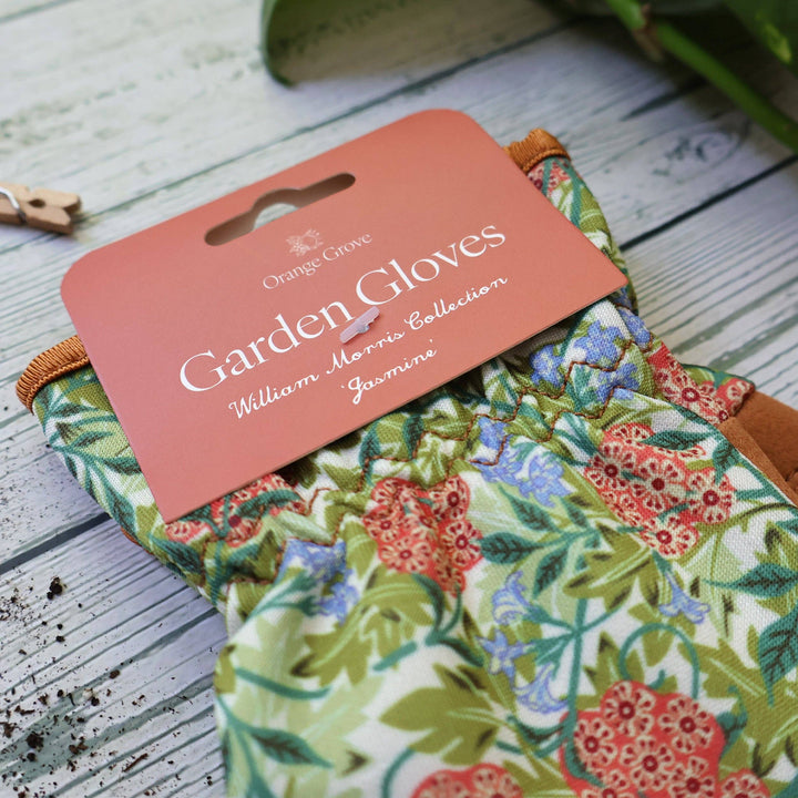 Floral garden gloves with a brand label on a wooden surface