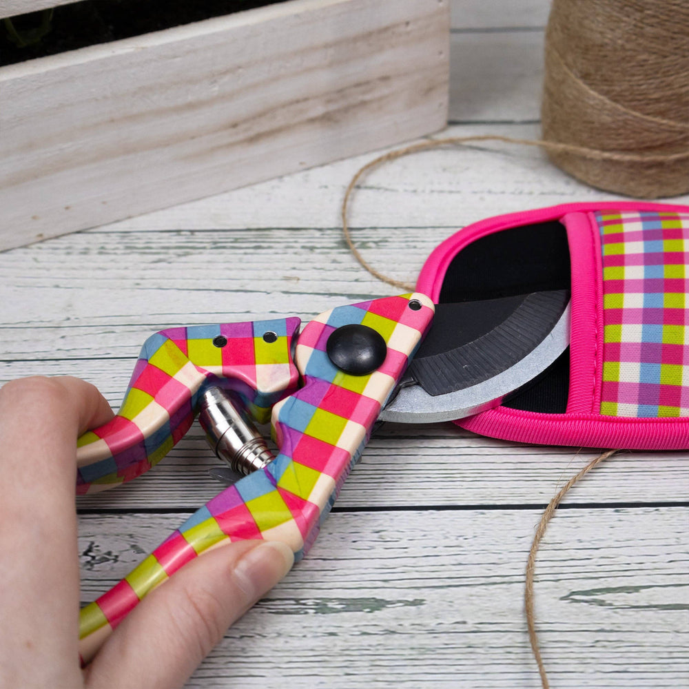 Colorful plier with checkered pattern held by a hand on a wooden surface.