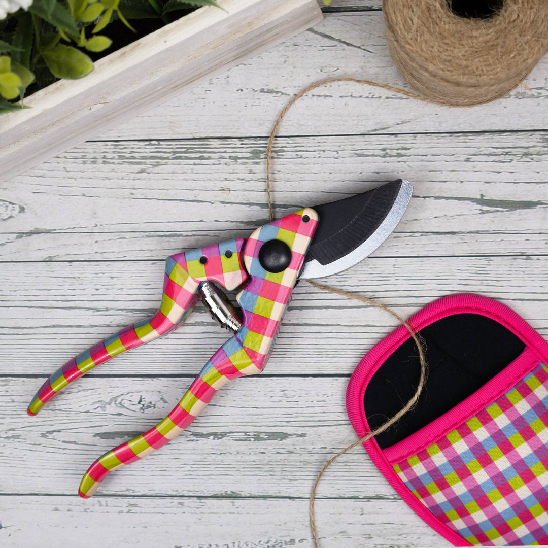 Gardening shears with colorful plaid handles on a wooden surface.