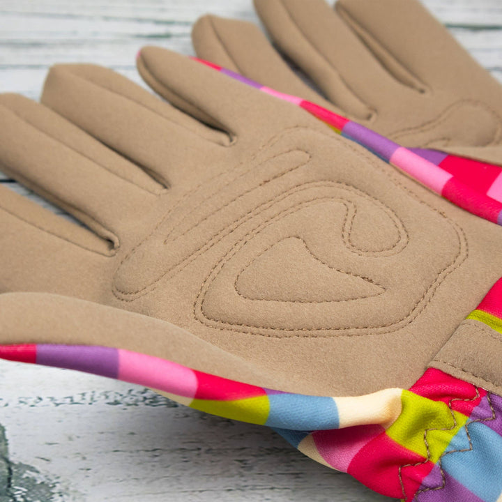Pair of brown gloves with colorful trim on a wooden surface