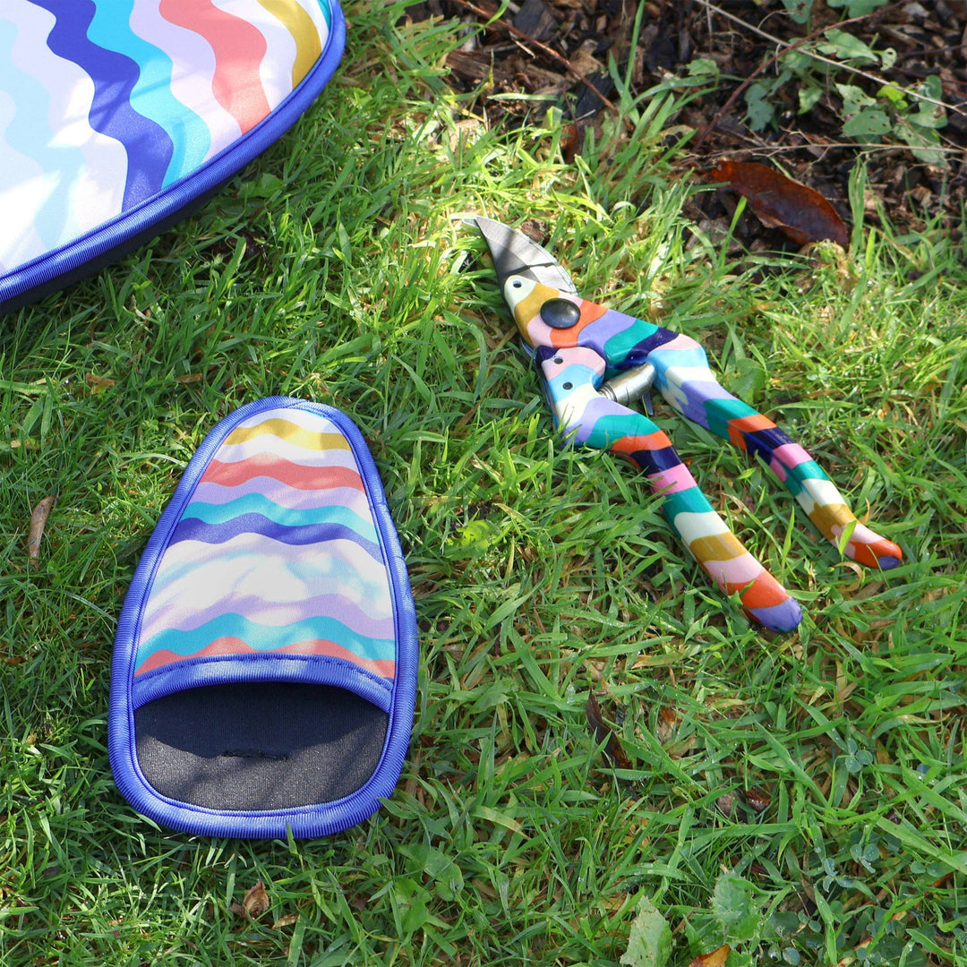 Colorful garden shears and slipper on grass