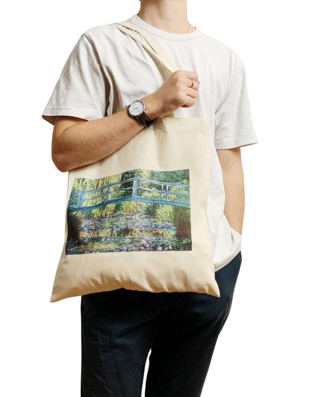 Person holding a tote bag with a scenic design on a white background