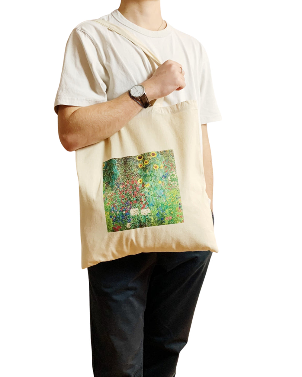Person holding a tote bag with a artistic design on a white background