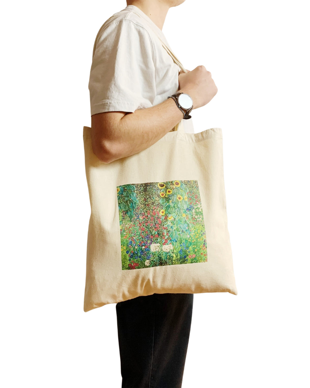 Person holding a tote bag with a artistic design on a white background