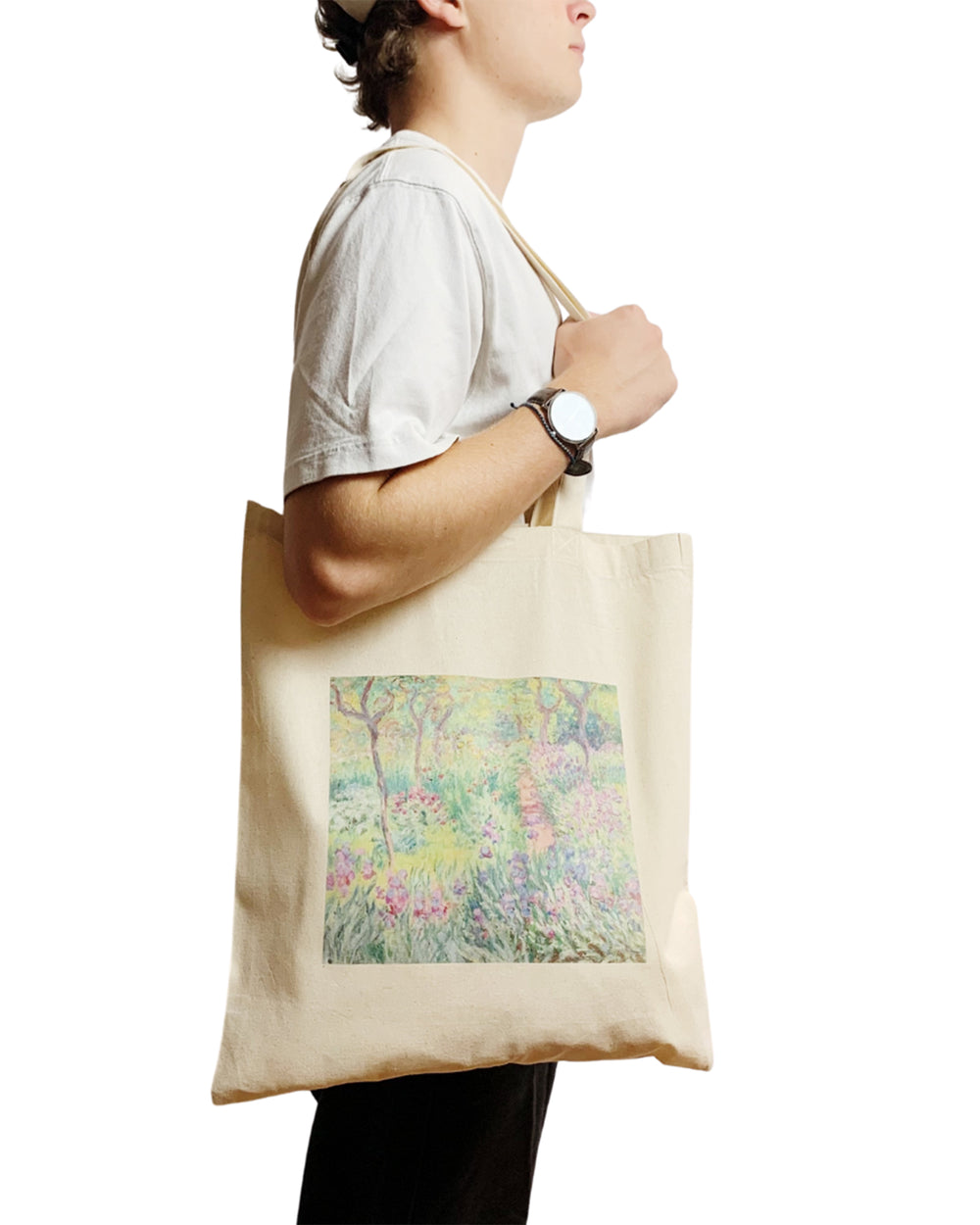Person holding a beige tote bag with a floral design on a white background