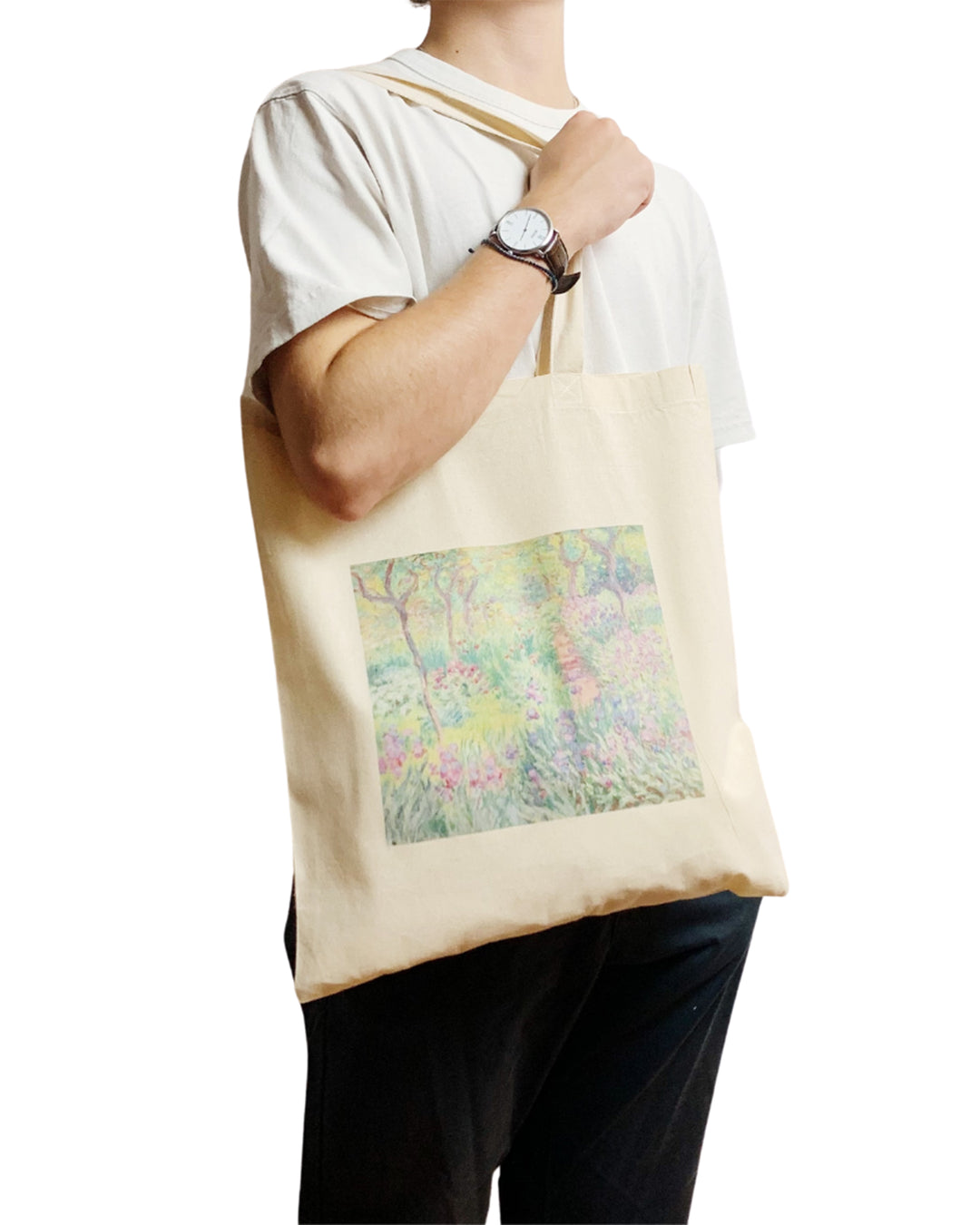 Person holding a beige tote bag with a colorful design on a white background
