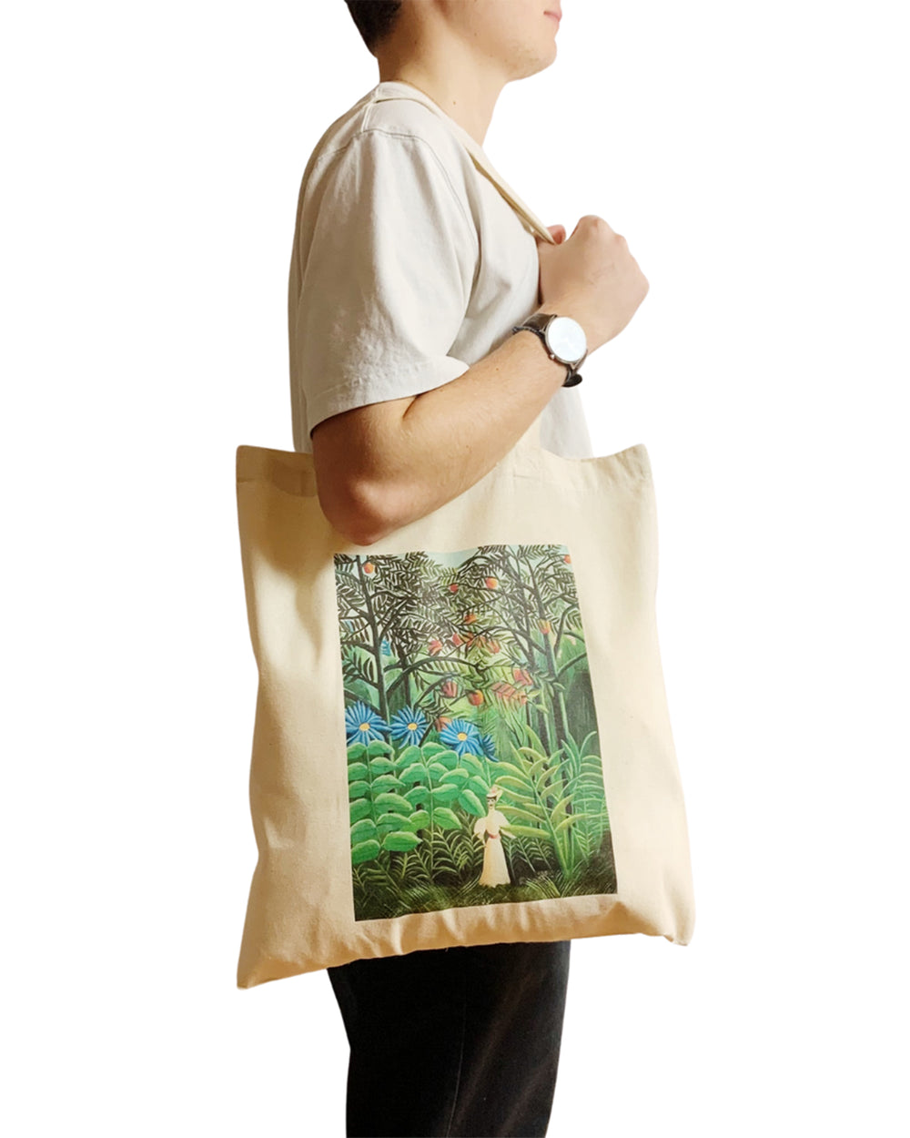 Person holding a tote bag with a jungle design on a white background