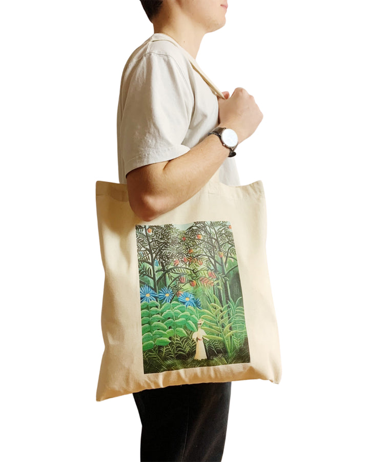 Person holding a tote bag with a jungle design on a white background