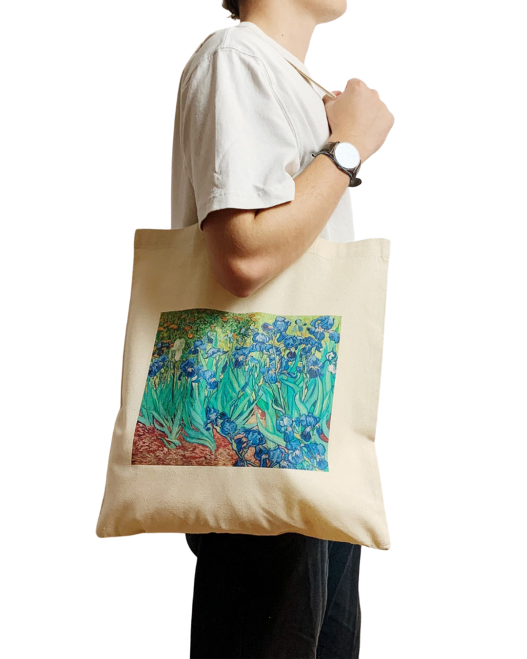 Person holding a tote bag with Van Gogh's 'Irises' design on a white background