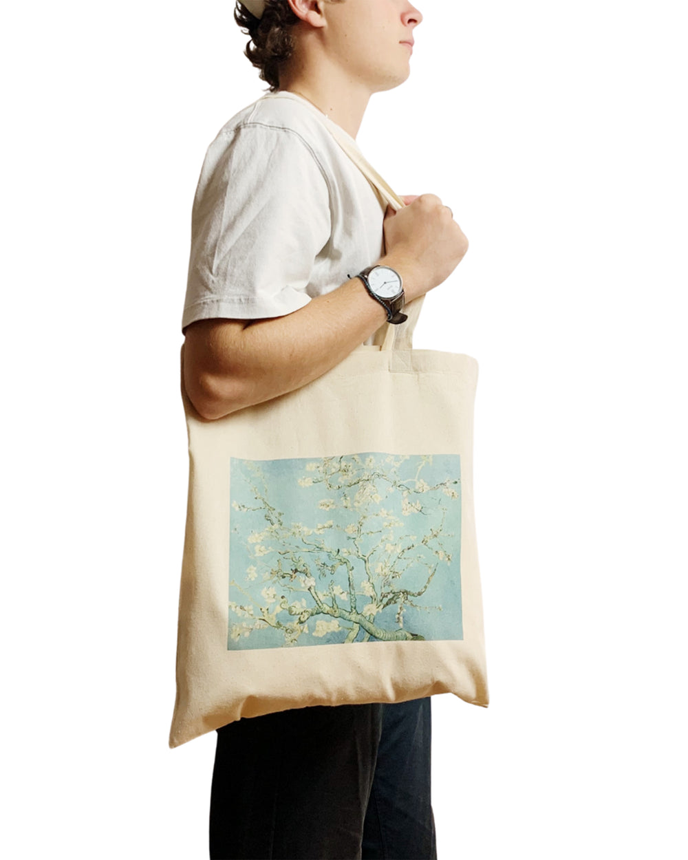 Person holding a tote bag with a floral design on a white background